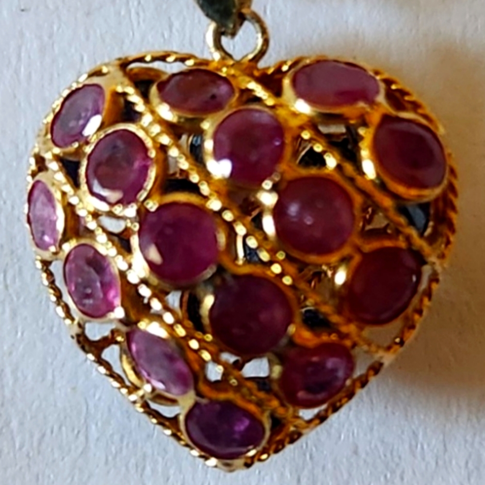 This puff heart pendant necklace features sapphires and rubies.